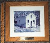 A framed picture of a house

Description automatically generated with low confidence