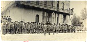 A group of people in uniform standing in front of a building

Description automatically generated