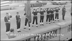 A group of people in uniform holding flags

Description automatically generated