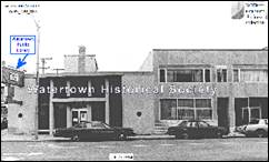 A black and white photo of a building with a car parked in front

Description automatically generated with medium confidence