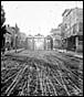 A black and white photo of a train track with buildings on either side

Description automatically generated with low confidence